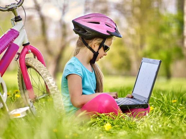 Bikes cycling girl wearing helmet  in cycling sitting near bicycle and watch pc tablet.