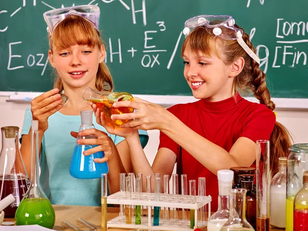 Children holding flask in chemistry class.