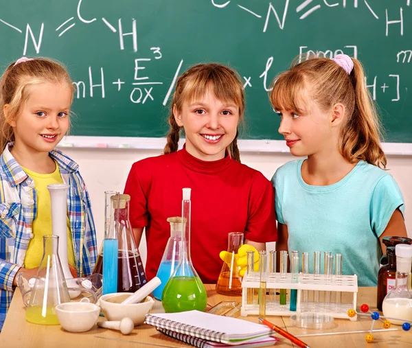 Group children keep flasks on lesson in chemistry class.