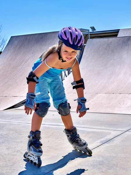 Girl riding on roller skates in skatepark.