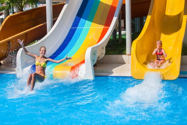 Two children on water slide at aquapark.