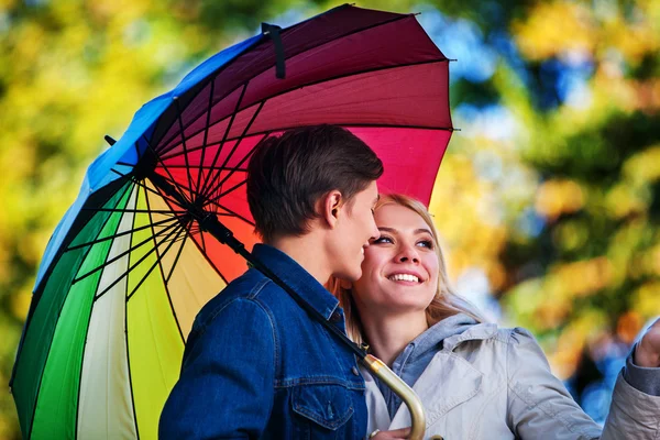Loving couple on date under umbrella.