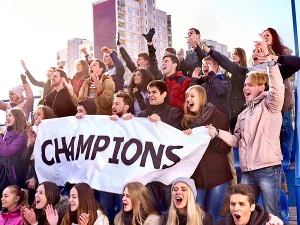 Sport fans keep champion banner on tribunes.