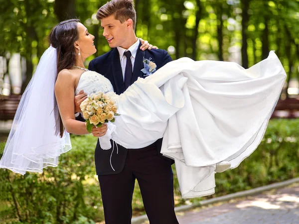 Bride and groom with flowers outdoor.