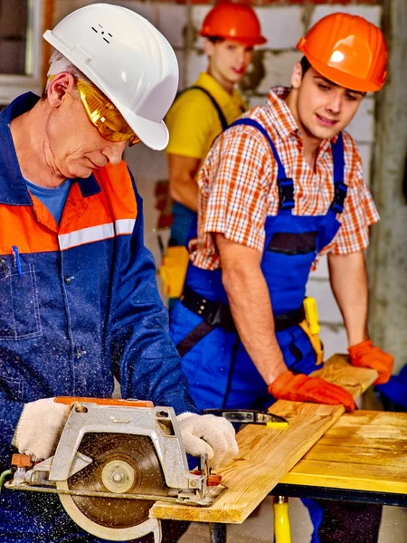 Group people  builder with circular saw .