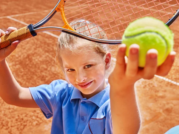Child with racket and ball on  tennis court