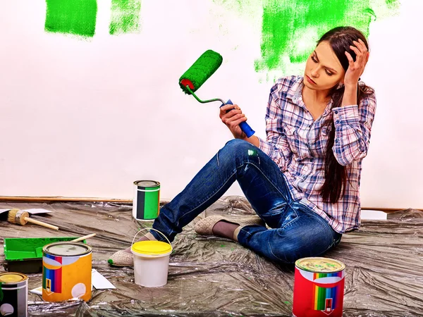 Woman paint wall at home.