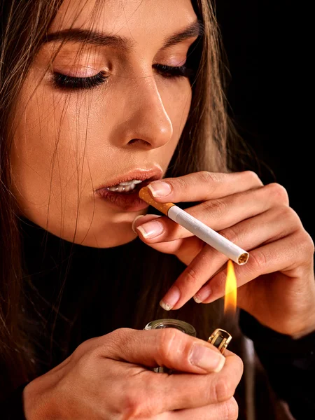 Woman smokes cigarette.