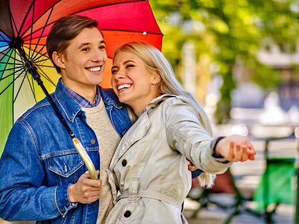 Loving couple on a date under umbrella.