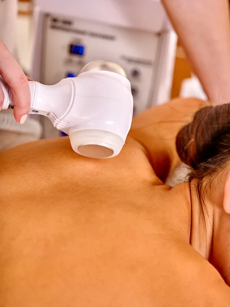 Woman receiving electricity microdermabrasion massage at beauty salon.