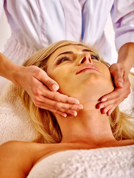 Woman middle-aged take face massage in spa salon.