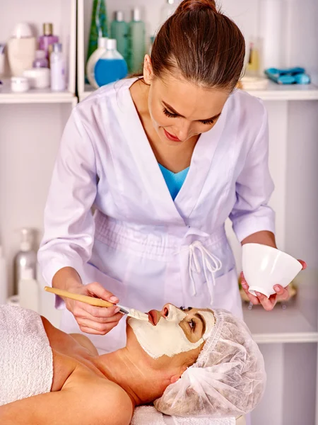 Woman middle-aged take face massage in spa salon.