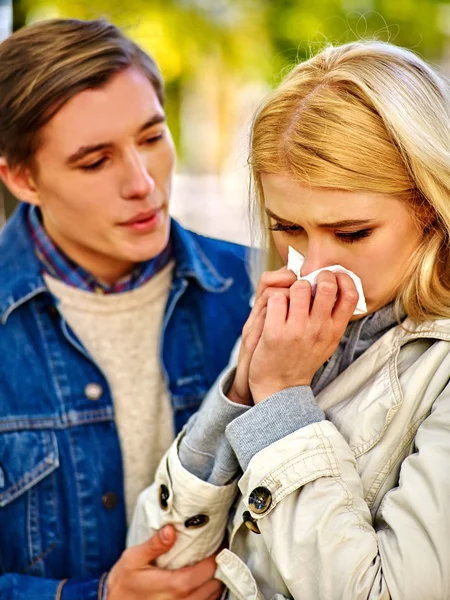 People with a cold blowing nose handkerchief fall outdoor.