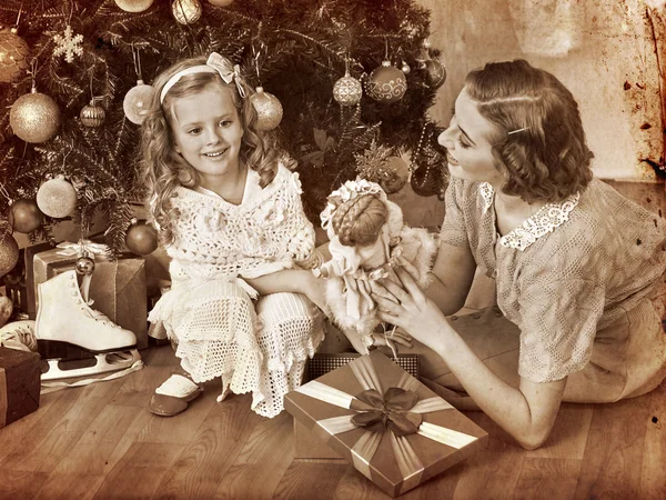 Girl with mother under Christmas tree
