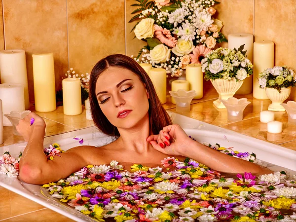 Woman take bath with flowers petals