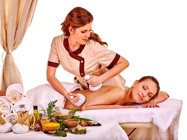 Woman getting herbal ball massage treatments .