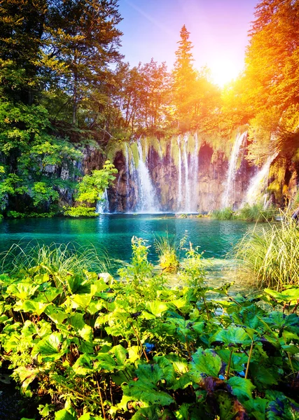 Waterfall with turquoise water and sunny beams
