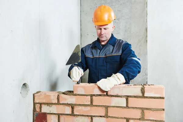 Bricklayer at work with red brick