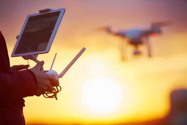 Drone quadcopter flying at sunset