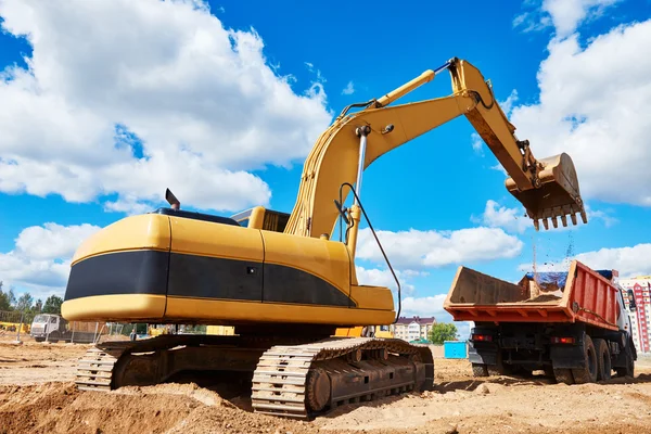 Loader excavator moving earth into dumper truck