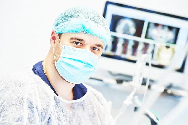 Portrait of male dentist wearing surgical mask and cap