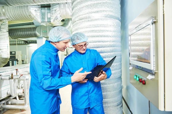 Pharmaceutical male workers in water preparation production line