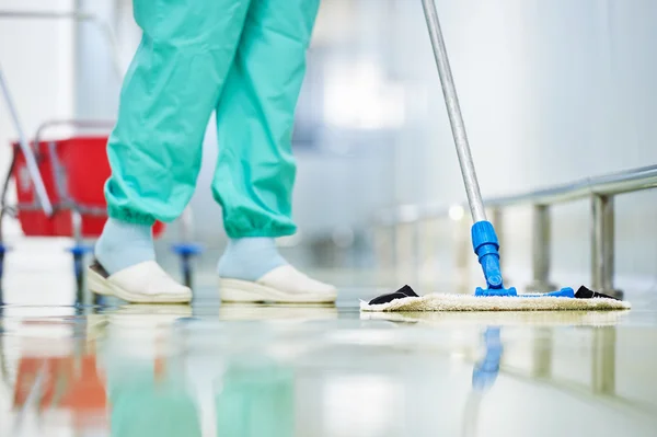 Worker cleaning floor with mop