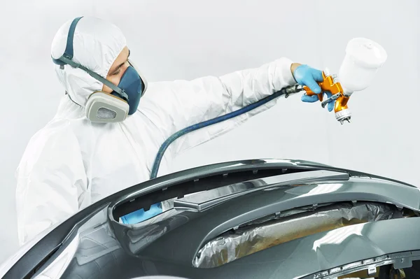 Worker painting auto car bumper