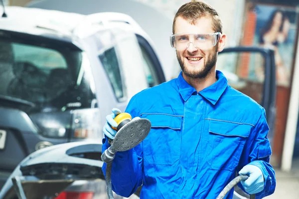 Portrait of auto mechanic worker with power polisher machine