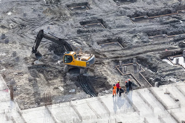 Working excavator with builders stand near