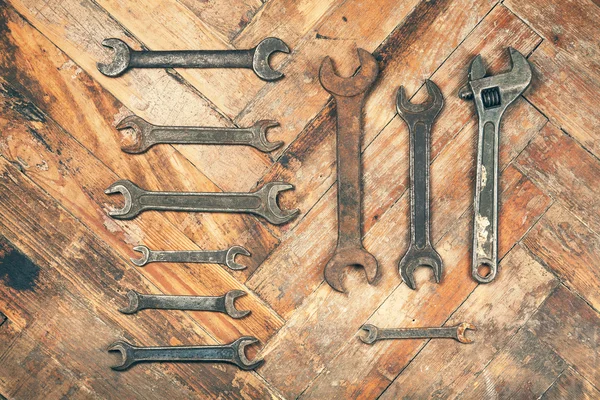 Set of old wrenches on wooden floor