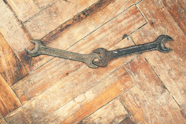 Two open-end wrenches on wooden floor