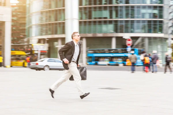 Businessman running in the city, panning image
