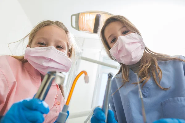 Little Female Dentists Holding Dental Tools Looking at Camera.