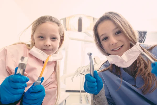 Little Female Dentists Holding Dental Tools Looking at Camera.