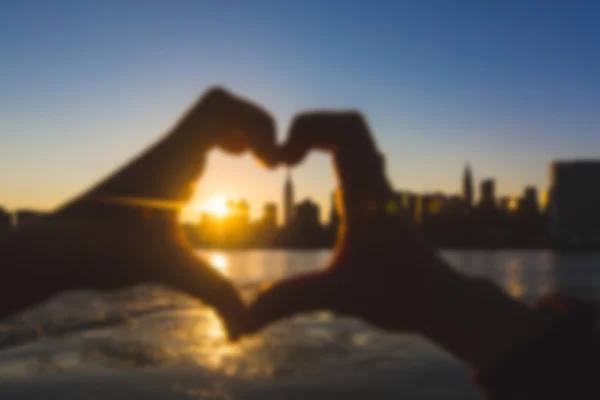 Heart Shaped Hands with New York Skyline. Blurred Background.
