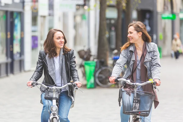 Two women going by bike in Copenhagen.