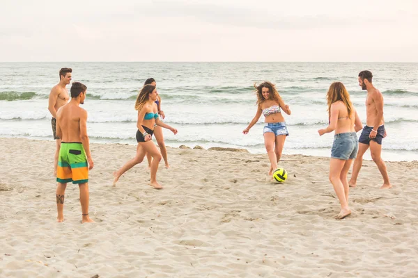 Group of friends playing with ball on the beach