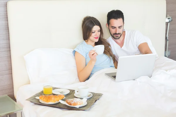 Couple having breakfast on the bed