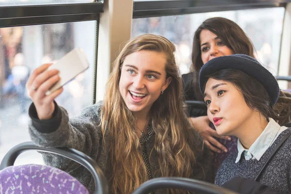 Three womentaking a selfie in the bus