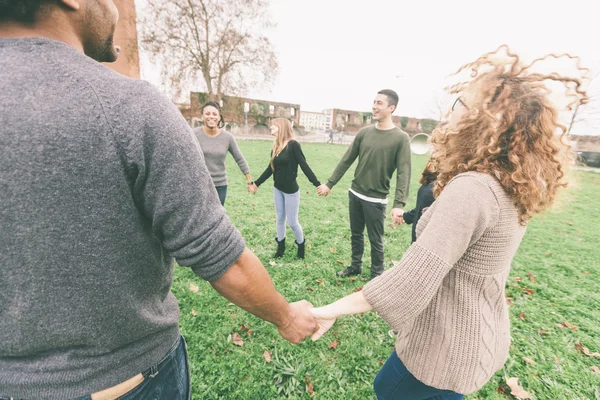 Multiethnic group of friends holding hands in a circle