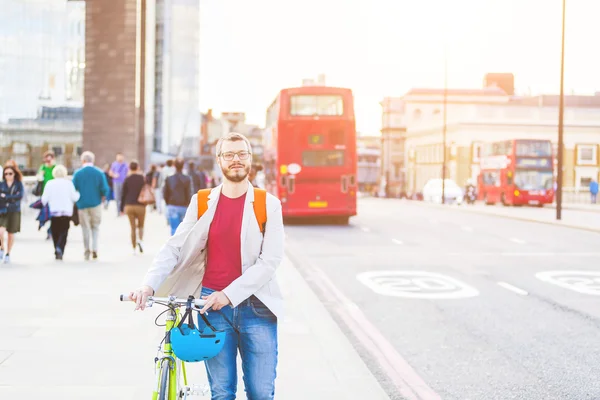 Hipster man walking on London bridge and holding his fixed gear