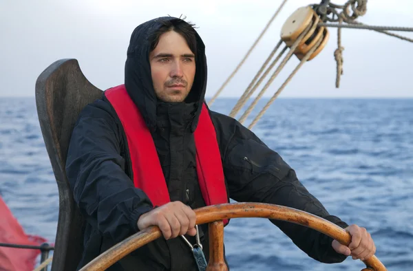 Young sailor steering tall ship