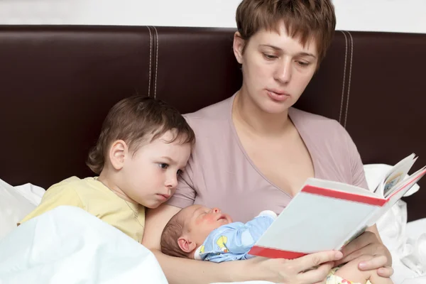 Mother reading book for her sons