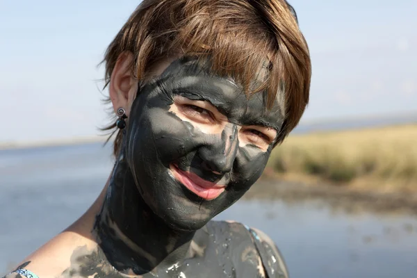 Woman face covered with mud