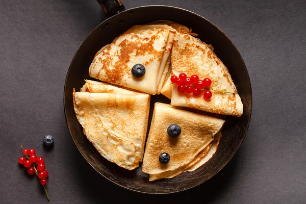 Pancakes with berries in pan