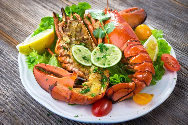 Boiled lobster with vegetables and herbs