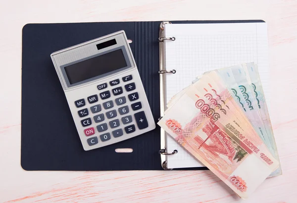 Money, calculator and blank notepad