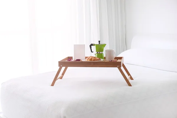 Breakfast tray with coffee on bed