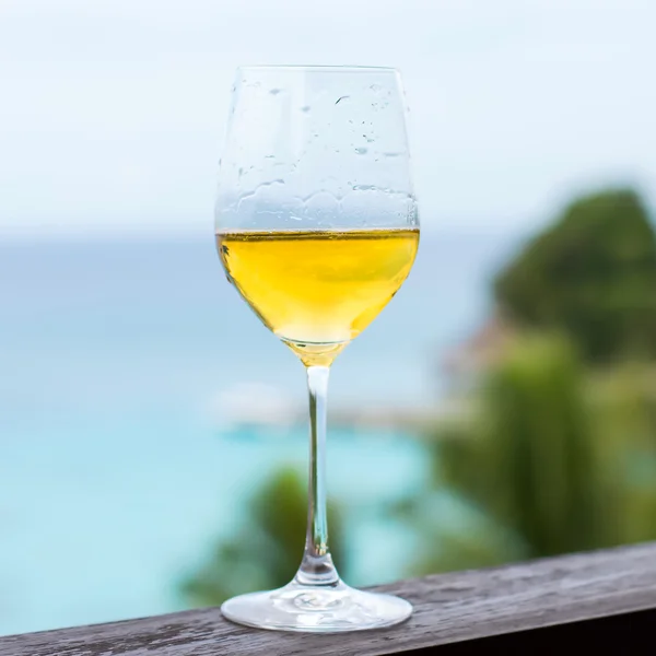 Glass of white wine on balcony rail